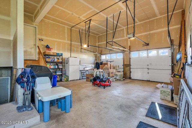 garage with a garage door opener and white fridge