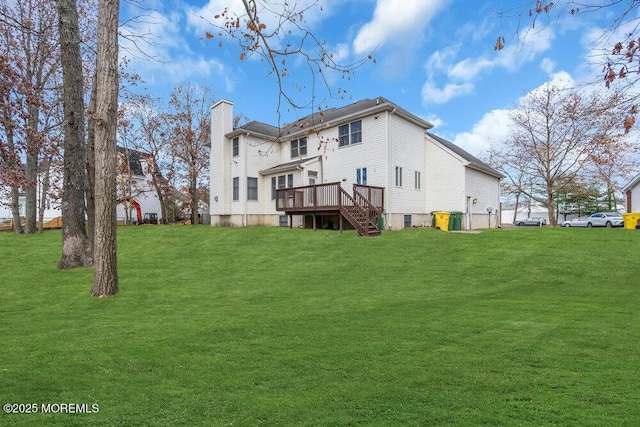 rear view of property featuring a lawn and a deck