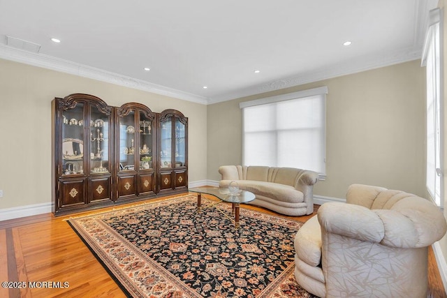 living room with ornamental molding and light hardwood / wood-style floors