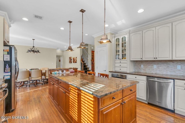 kitchen featuring pendant lighting, a center island, white cabinets, and appliances with stainless steel finishes