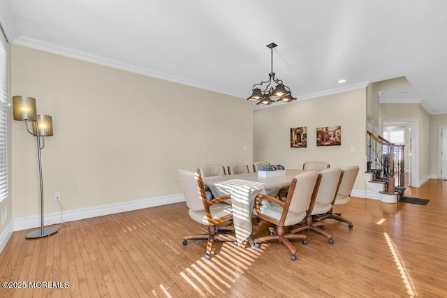 dining area with light hardwood / wood-style flooring and ornamental molding