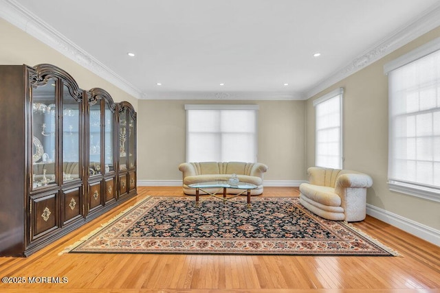 living room featuring a wealth of natural light, ornamental molding, and wood-type flooring