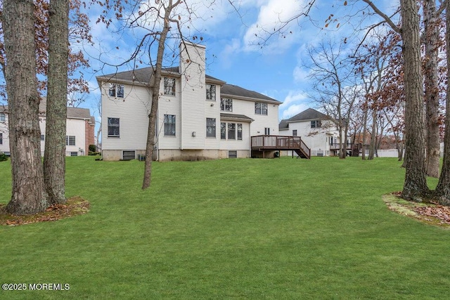 rear view of house featuring a yard and a deck