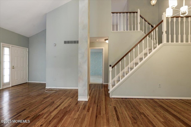 foyer featuring dark hardwood / wood-style floors, high vaulted ceiling, and a notable chandelier