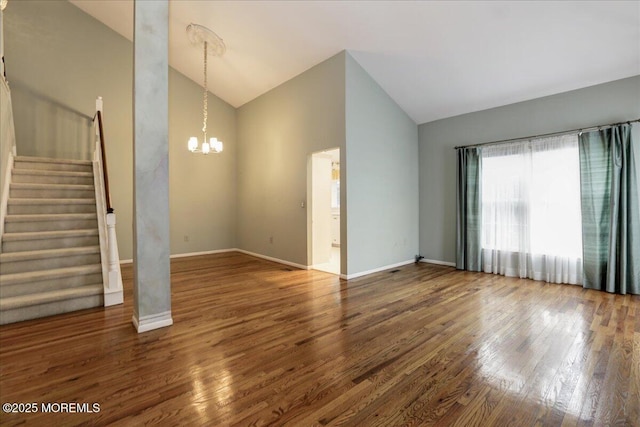 unfurnished living room featuring an inviting chandelier, wood-type flooring, and high vaulted ceiling