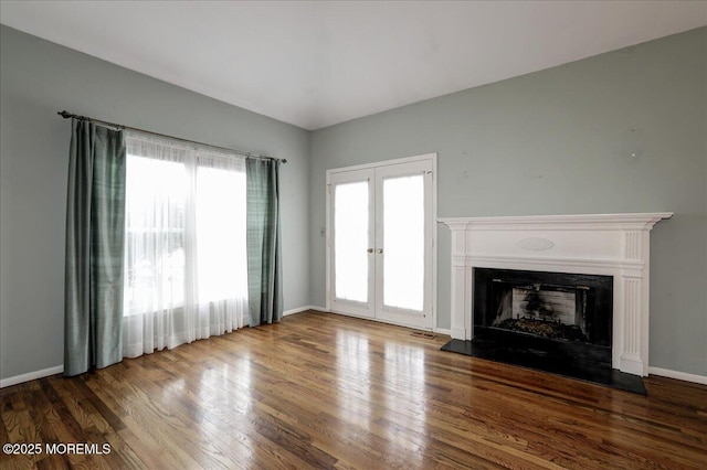 unfurnished living room featuring hardwood / wood-style floors and french doors