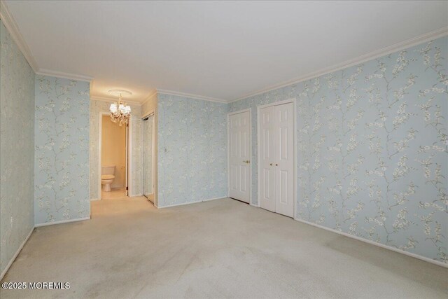 carpeted spare room with an inviting chandelier and crown molding