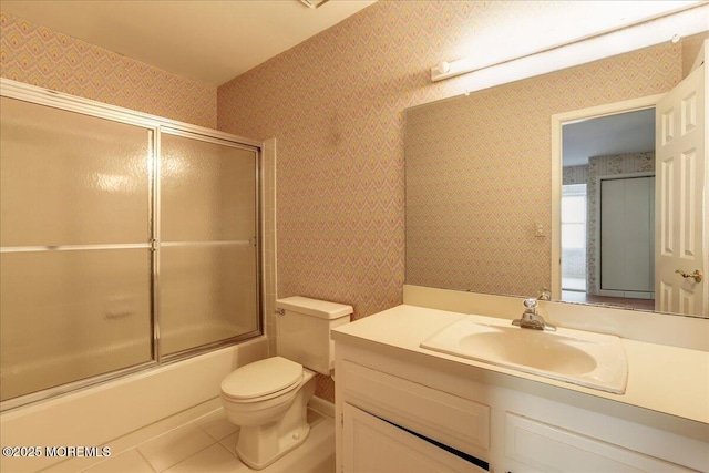 full bathroom with vanity, tile patterned flooring, bath / shower combo with glass door, and toilet