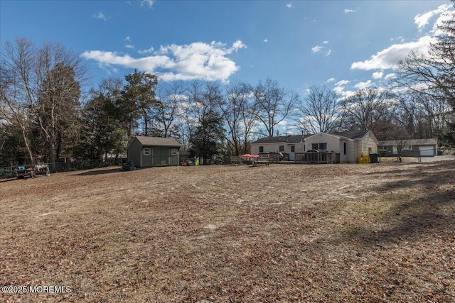 view of yard featuring a deck and a storage unit