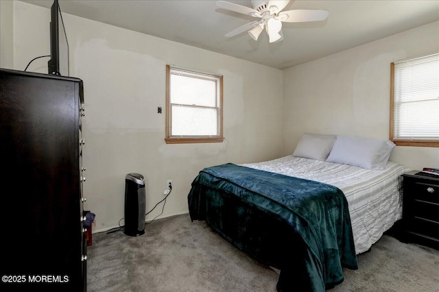 carpeted bedroom with multiple windows and ceiling fan