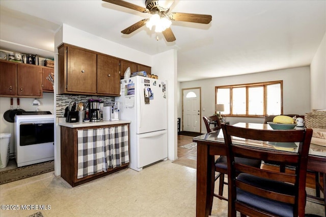 kitchen featuring tasteful backsplash, washer / clothes dryer, ceiling fan, and white fridge