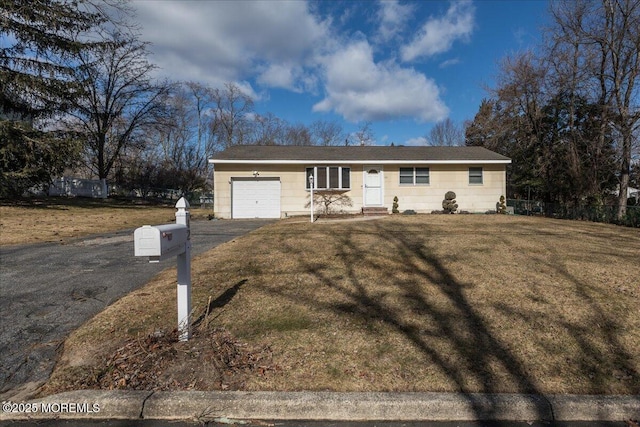 ranch-style home featuring a garage and a front lawn