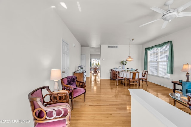 sitting room featuring ceiling fan, light wood-type flooring, and visible vents