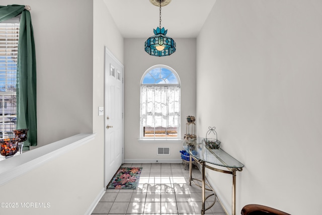 interior space featuring tile patterned flooring, visible vents, and baseboards