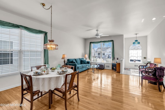 dining space featuring light wood-type flooring, ceiling fan, and baseboards