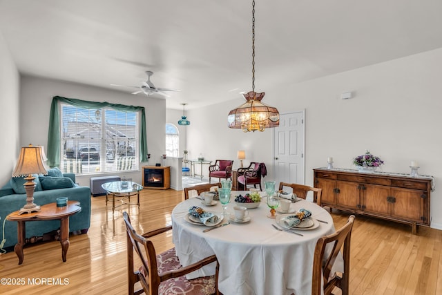 dining area with light wood-style floors and a ceiling fan