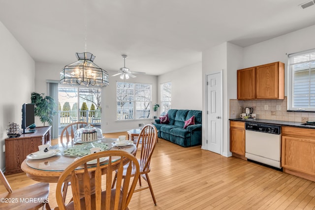 dining space featuring light wood finished floors, plenty of natural light, visible vents, and a notable chandelier