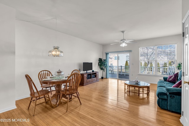 dining room with ceiling fan, light wood-style flooring, and baseboards