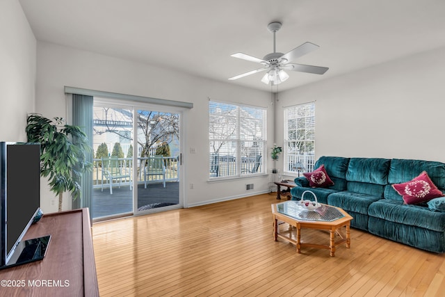 living area featuring a ceiling fan, a healthy amount of sunlight, and hardwood / wood-style floors