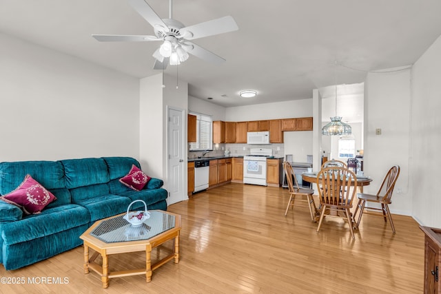 living room with light wood finished floors and a ceiling fan