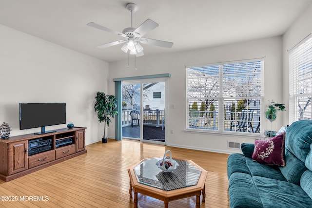 living room featuring visible vents, ceiling fan, light wood-style flooring, and baseboards