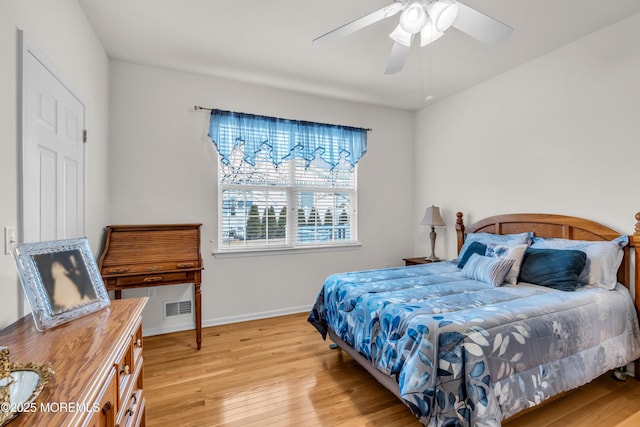 bedroom featuring a ceiling fan, light wood-type flooring, visible vents, and baseboards