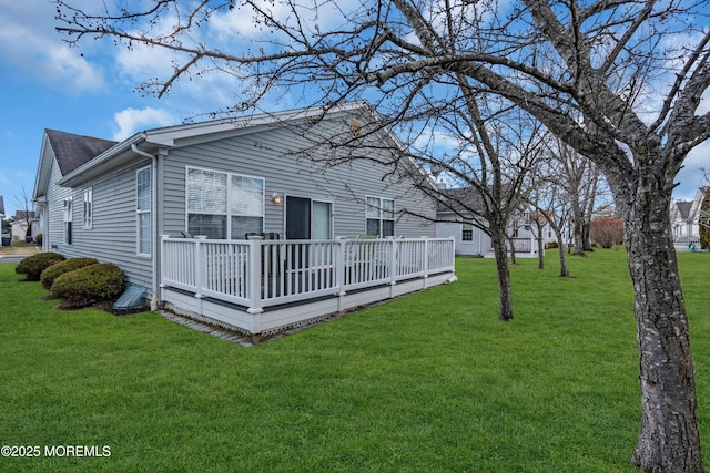 rear view of property featuring a yard and a wooden deck