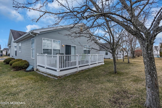 rear view of property featuring a yard and a wooden deck