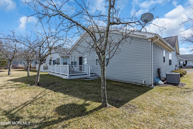 view of side of home featuring a lawn, a wooden deck, and central air condition unit