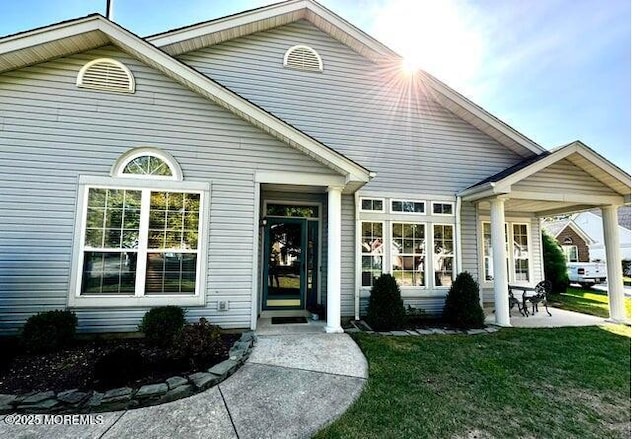 rear view of property featuring a lawn