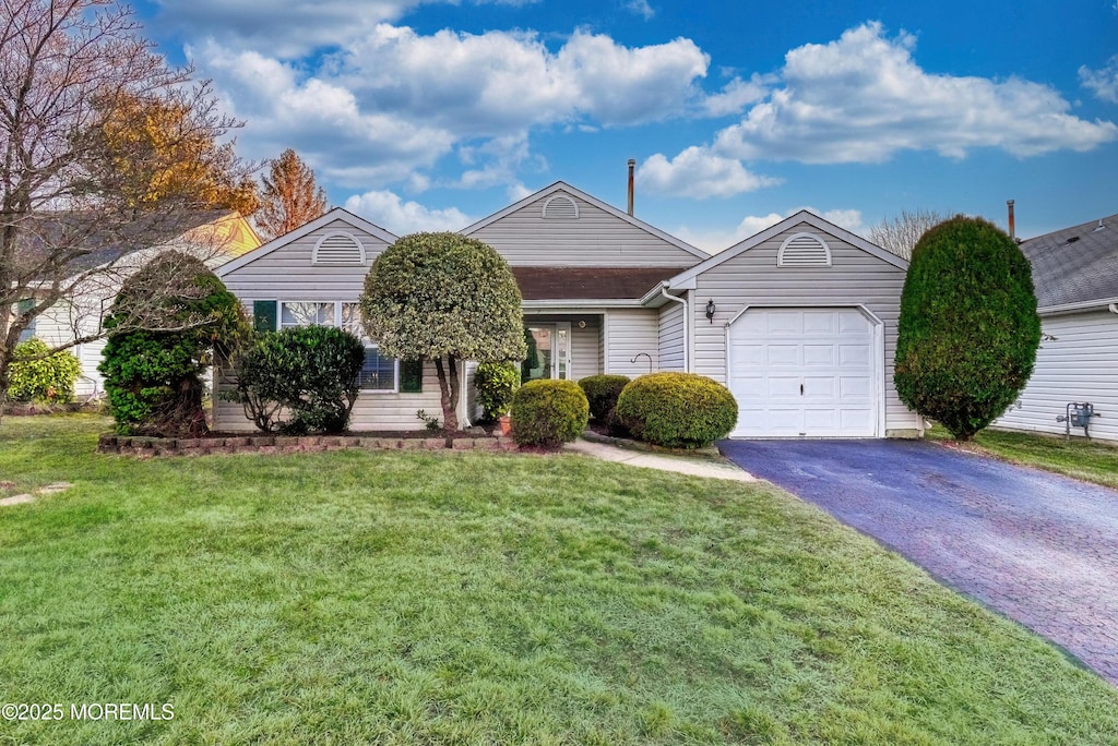 single story home featuring a garage and a front yard