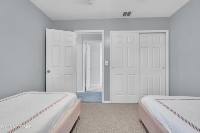 bedroom with light colored carpet and a closet