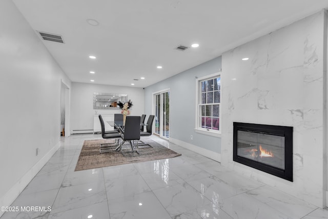 dining space featuring a premium fireplace and baseboard heating