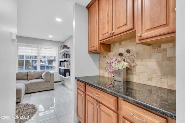 kitchen featuring tasteful backsplash and dark stone countertops