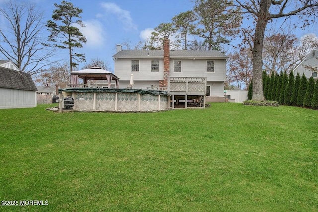 back of house featuring a gazebo, a yard, and a pool side deck