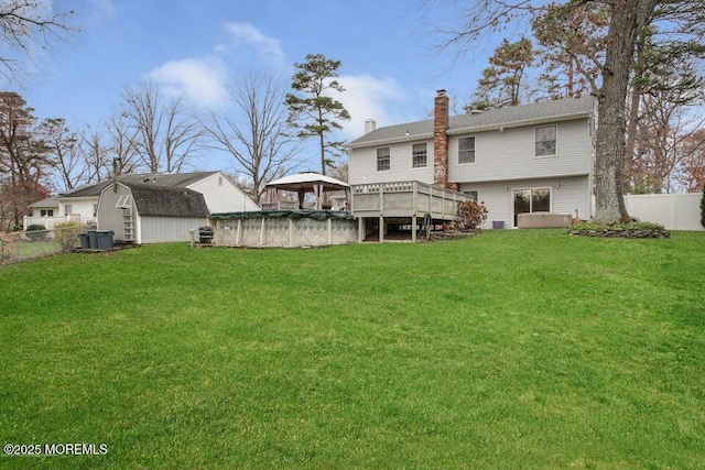 back of property with a gazebo, a swimming pool side deck, and a lawn