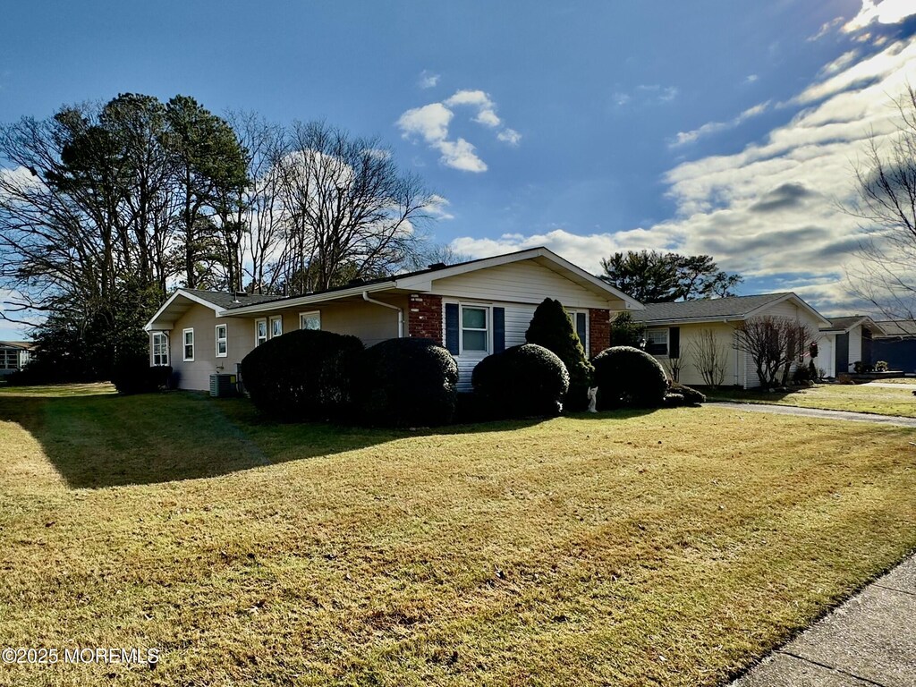 view of front of home featuring central AC and a front lawn