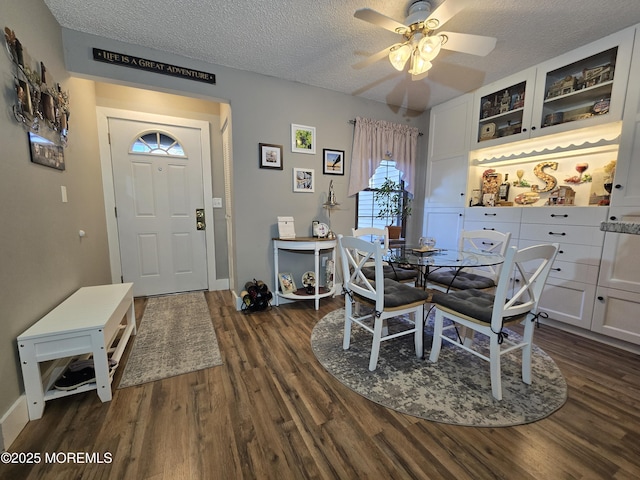 dining room with dark hardwood / wood-style flooring, ceiling fan, and a textured ceiling