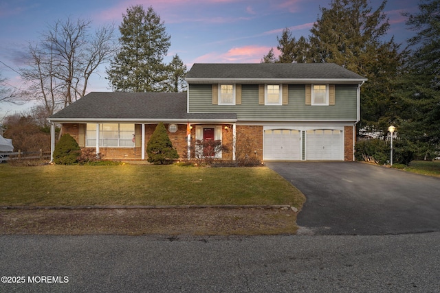 view of property featuring a garage and a yard