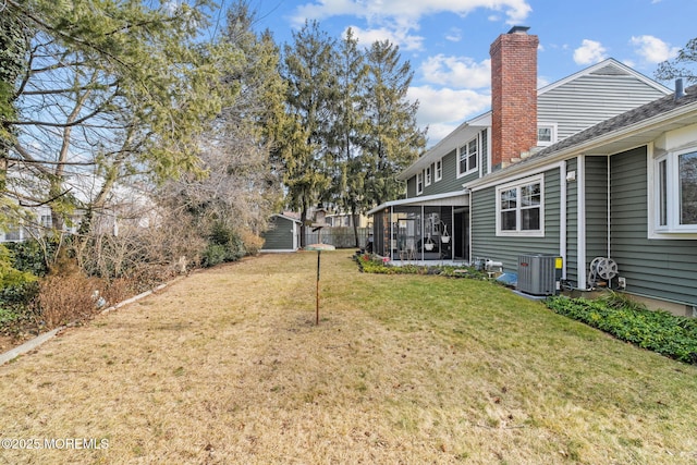 view of yard with central AC and a sunroom