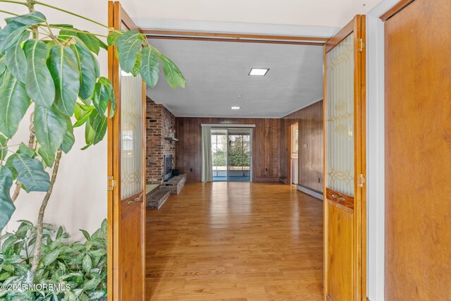 hallway featuring wood walls and light wood-type flooring