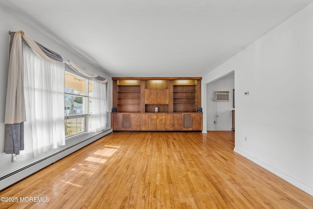 unfurnished living room featuring a baseboard radiator, an AC wall unit, and light wood-type flooring