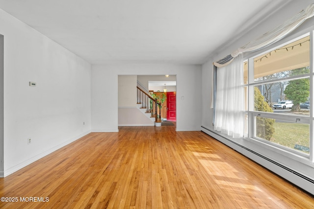 empty room with a baseboard heating unit and light wood-type flooring