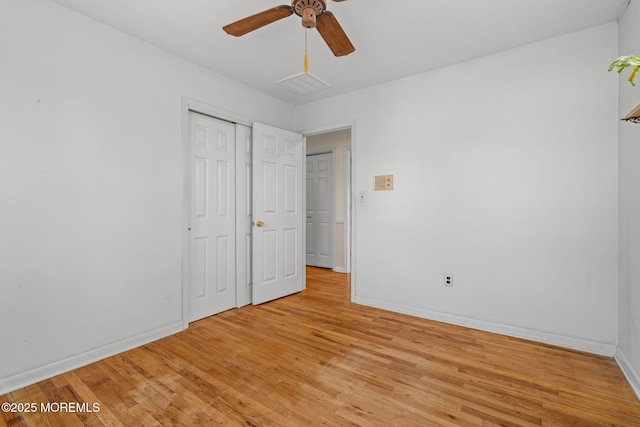 unfurnished bedroom with ceiling fan, light wood-type flooring, and a closet