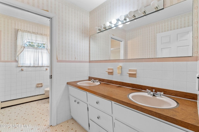 bathroom with a baseboard radiator, vanity, toilet, and tile walls