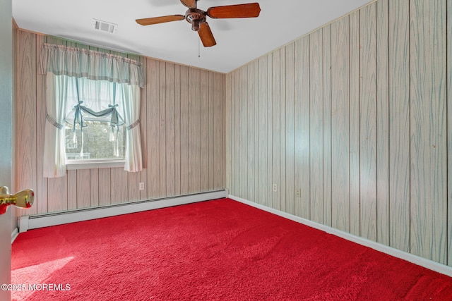 spare room featuring carpet, ceiling fan, and baseboard heating