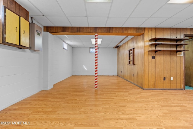 basement with a drop ceiling and light wood-type flooring