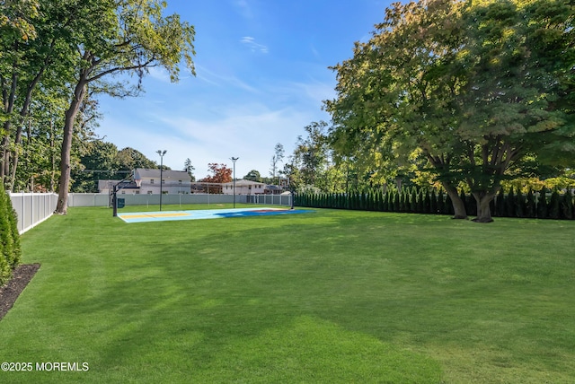 view of yard featuring basketball hoop