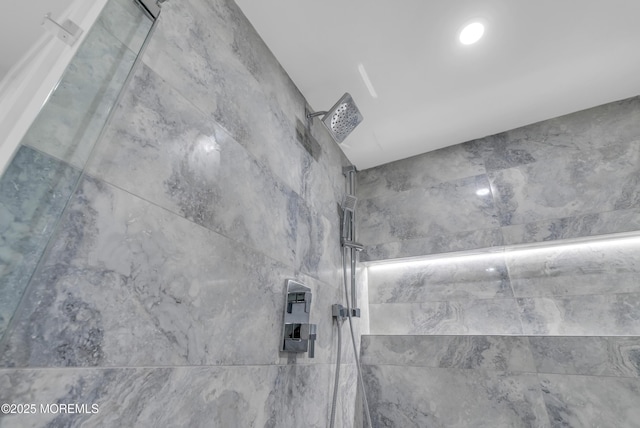 interior details featuring tiled shower