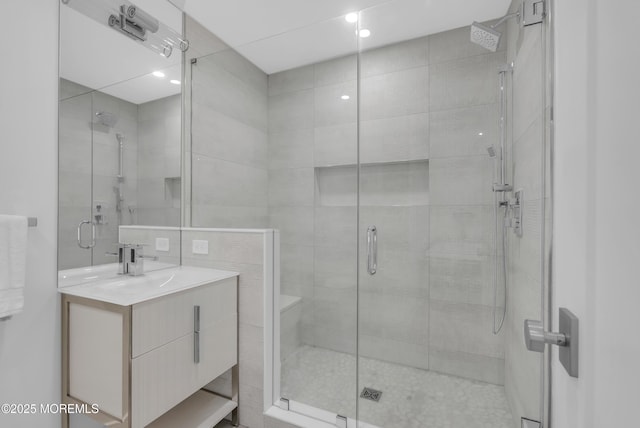 bathroom with vanity, tile walls, and walk in shower